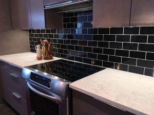 modern-kitchen-in-dark-tones-with-black-tiled-wall-scaled